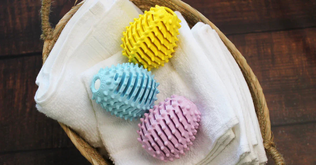 Three Ecoegg Dryer Eggs on a towel in a laundry basket