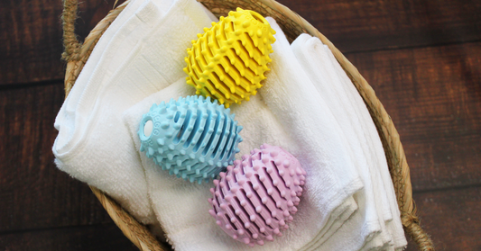 Three Ecoegg Dryer Eggs on a towel in a laundry basket