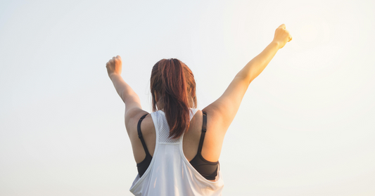 Woman raising arms in celebration on International Women's Day
